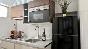 A modern kitchen with a black refrigerator, a built-in oven, and a sink. - Gondola Grand Canal (Historical Center) (Venecia)