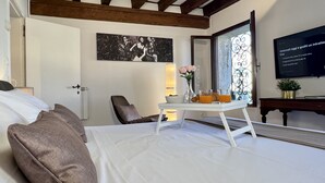 A hotel room with a bed, a bedside table with breakfast items, a painting on the wall, and a TV. - Gondola Grand Canal (Historical Center) (Venecia)