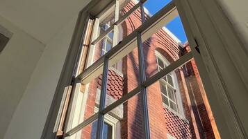 A window with a view of a red brick building.