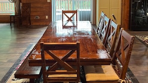 A wooden dining room with a large table, chairs, and a chandelier. - Charming 3,800 sq feet log house in Waupaca County.  (Ogdensburg)