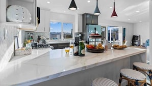 A modern kitchen with a large island, pendant lighting, and a view of the mountains. - Upscale Resort House /Views, Saltwater Pool/Spa !
 (Spring Valley)
