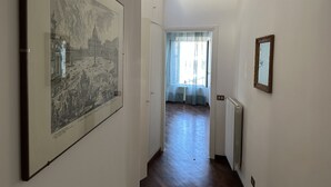 Ein Flur mit einer großen, gerahmten historischen Karte, einem Heizkörper und einem Spiegel an der Wand.