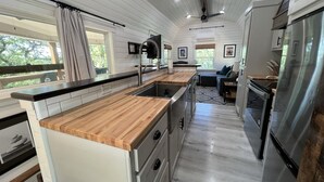 Une cuisine moderne avec des plans de travail en bois, des appareils électroménagers en acier inoxydable et un îlot central.