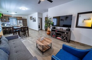 A modern living room with a sofa, a coffee table, and a TV.