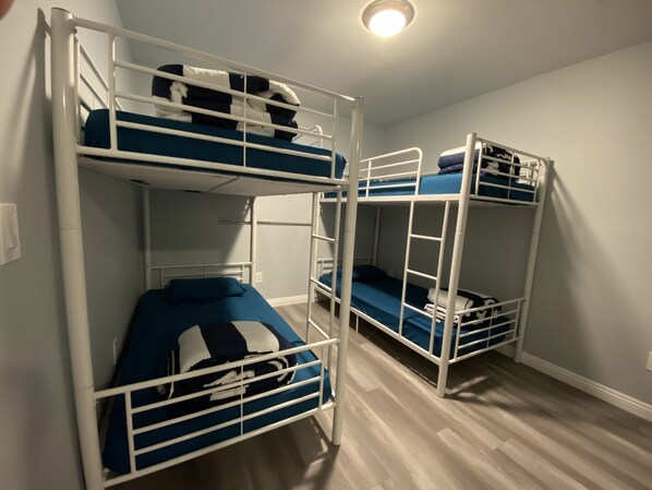 A room with bunk beds, wooden flooring, and a ceiling light. - Modern Hostel (Los Angeles)