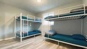 A room with two bunk beds, wooden flooring, and a window providing natural light. - Modern Hostel (Los Angeles)