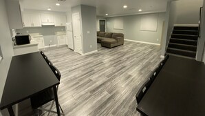 A spacious living area with a sectional sofa, a dining table, and a kitchen in the background. - Modern Hostel (Los Angeles)