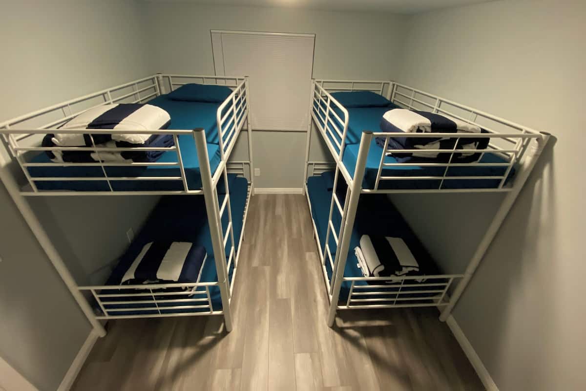 A room with four bunk beds arranged in a square layout.