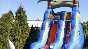 Una estructura inflable con toboganes, una escalera y una aleta de tiburón.