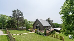 A log cabin with a deck and a fenced yard.