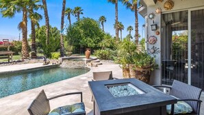 A poolside area with a hot tub, lounge chairs, and a pergola with palm trees. - Casa Royal Troon- Active 55+ Golf Course Community, Private Home w Pool and Spa! (Indio)
