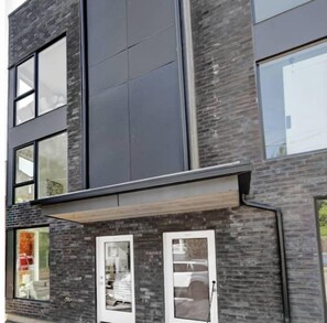 Stylish two-story building with a flat roof and large windows, featuring a grid-patterned facade.