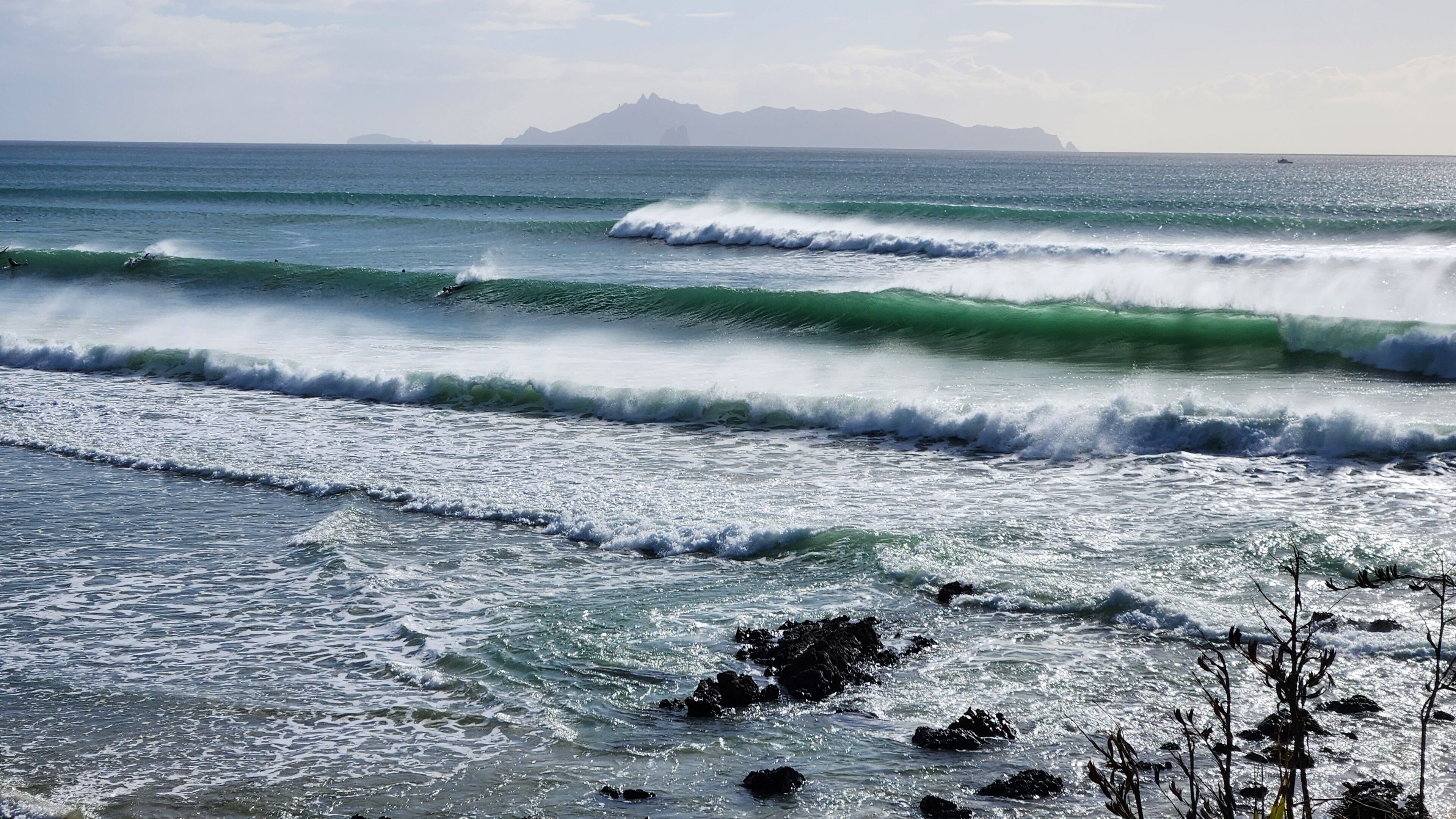 Una playa con olas y rocas.