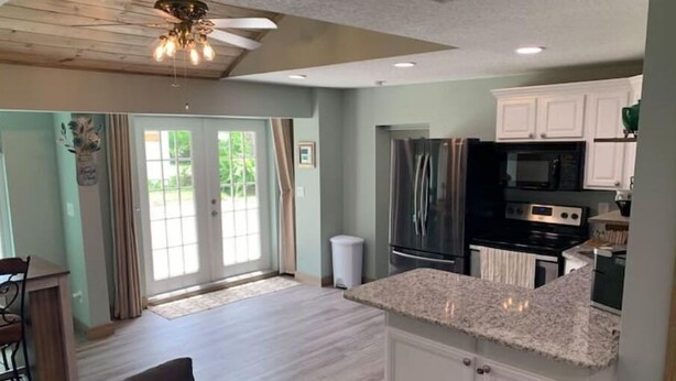 A spacious kitchen with white cabinets, a granite countertop, and stainless steel appliances. - Courtyard Bungalow
 (Melbourne)
