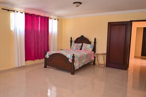 Cozy bedroom with a comfortable bed, nightstand, and window with curtains.