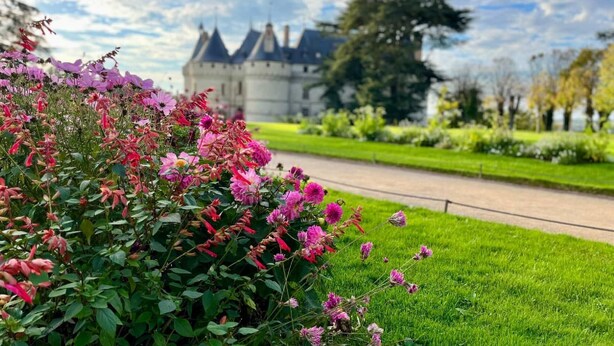 Un castillo con un jardín bien cuidado en primer plano.