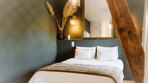 Un dormitorio con cama, espejo y plantas decorativas.