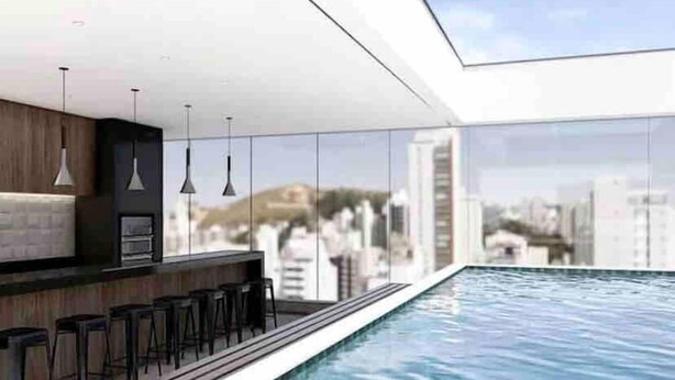 Un área de piscina interior moderna con bar y asientos.