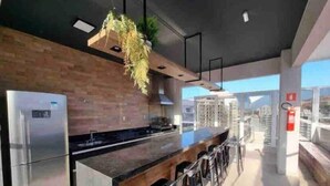 Una cocina moderna con un refrigerador de acero inoxidable, una encimera de madera y una planta colgante.