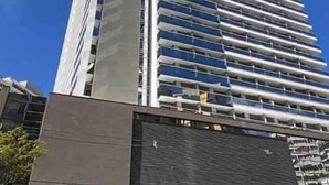 Un edificio alto y moderno con un diseño vertical llamativo y varias terrazas.