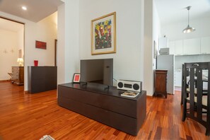 Una sala de estar moderna con un televisor de pantalla plana, un radio y una mesa de centro de madera.