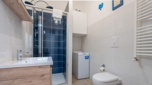 A modern bathroom with a shower, toilet, and sink. - Casa Novecento Prati (Roma)