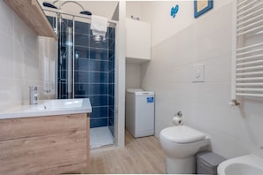 A modern bathroom with a shower, toilet, and sink.