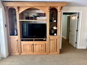Relax in this stylish living room with a large flat-screen TV and entertainment center.