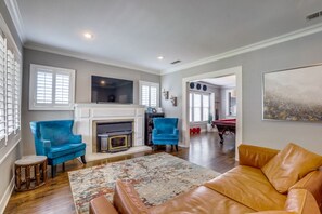 Cozy living room with a fireplace, comfortable seating, and a large painting.