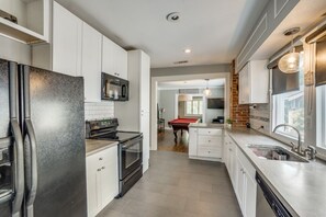 Enjoy cooking in this well-equipped kitchen with a large island, oven, and stainless steel appliances.