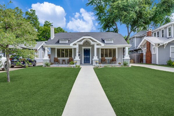 Stunning home with a central entrance and two sets of windows, set amidst a beautifully manicured lawn.