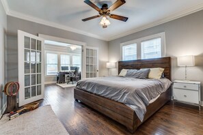 Relax in this serene bedroom with a large bed, ceiling fan, and comfortable nightstand.
