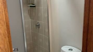 Een douche, handdoeken, zeep, shampoo