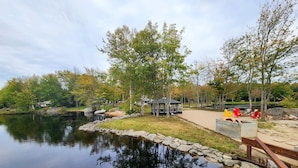 Ein Park am Seeufer mit einem Pavillon, Picknicktischen und einem Steg.