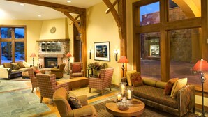 A spacious living room with a fireplace, comfortable seating, and large windows offering views of the outside. - Room with Ski-in/Ski-out Access | Rooftop Hot Tub (Park City)