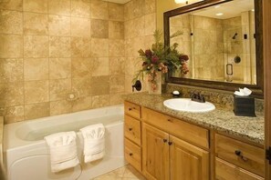 Ein Badezimmer mit einer Badewanne, einem Waschbecken, Holzschränken und einem Spiegel.