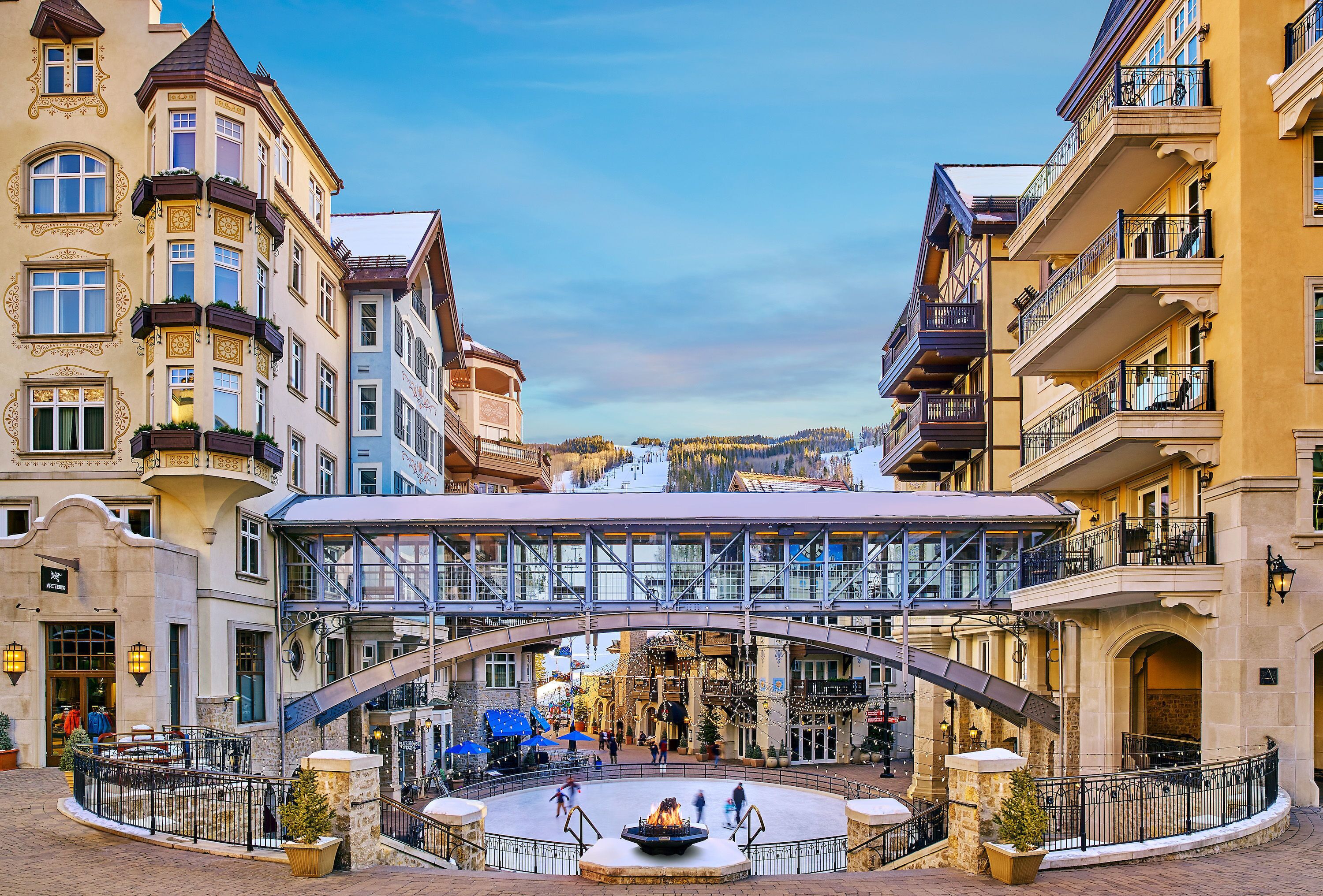 Un edificio storico con un cortile centrale, un ponte in vetro e una fontana.
