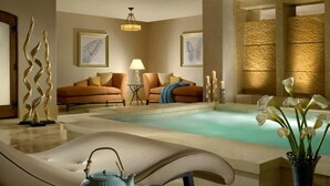 A spa area with a pool, a lounge chair, a sofa, and decorative elements like candles and flowers. - Lavish Room + Access to Rooftop Hot Tubs & Pool (Vail)