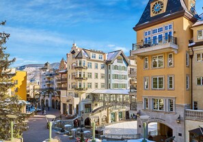 A historic town square with a prominent clock tower, a covered bridge, and traditional European architecture. - Lavish Room + Access to Rooftop Hot Tubs & Pool (Vail)