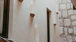 Fachada de un edificio con varias ventanas y un muro de piedra.