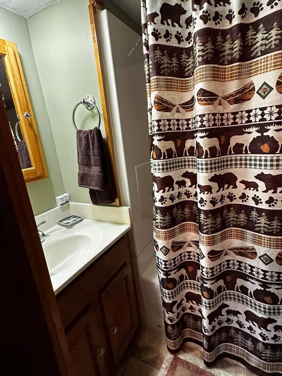 Une salle de bain avec un lavabo blanc, un meuble en bois et un miroir.