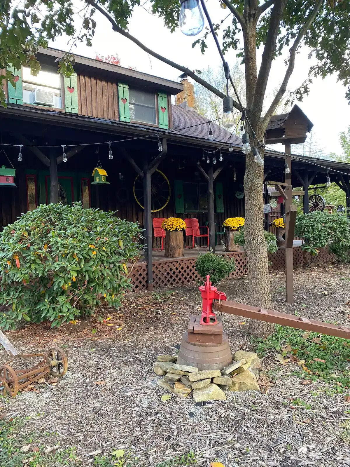 A rustic building with a porch, outdoor seating, and a decorative fire hydrant.