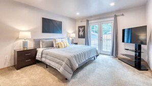 A bedroom with a bed, bedside tables, a TV, and a window with curtains. - Tranquil Urban Oasis in Bonney Lake (Bonney Lake)