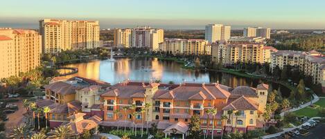 A hotel complex with a central courtyard, surrounded by high-rise buildings, and a lake with fountains.