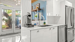 A modern kitchen with a coffee machine, stainless steel appliances, and a view of the outdoors. - Stylish Scottsdale Home W/ Pool Heating! (Scottsdale)