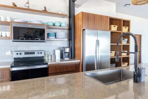 A modern kitchen with a built-in oven, microwave, and stainless steel refrigerator. - Beachfront Villa with Heated Pool (La Paz)