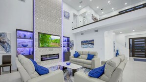Un salon moderne avec un canapé, une table basse et un téléviseur fixé au mur.