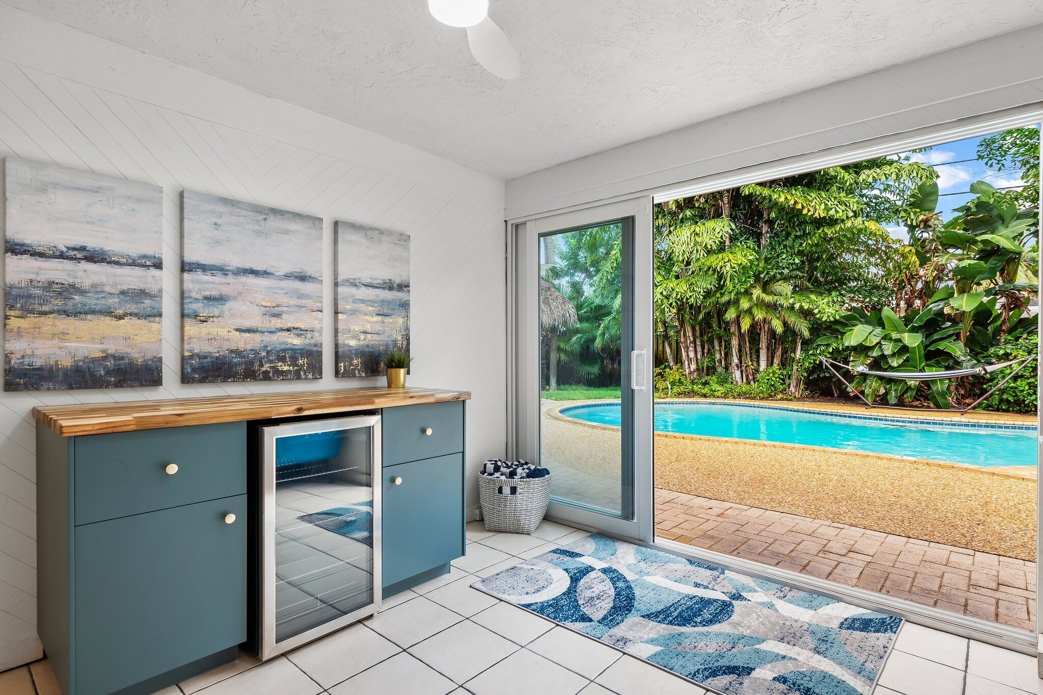 Une cuisine moderne avec vue sur une piscine et une végétation luxuriante.