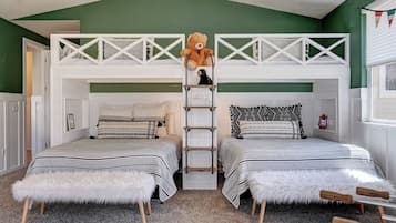Ein Zimmer mit zwei Stockbetten, einer Leiter, einem Teddybären und einem kleinen Regal mit einer Laterne.