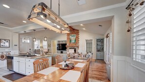 A spacious kitchen with a central island, wooden chairs, and a dining table. - Beautifully furnished home with HOT TUB (Angels Camp)